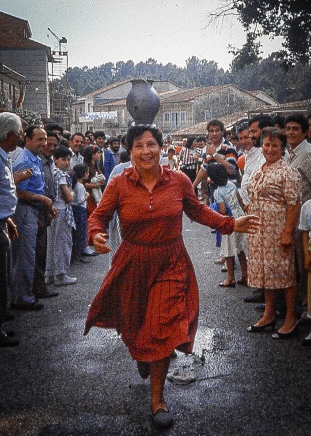 mulher correndo com cântaro à cabeça